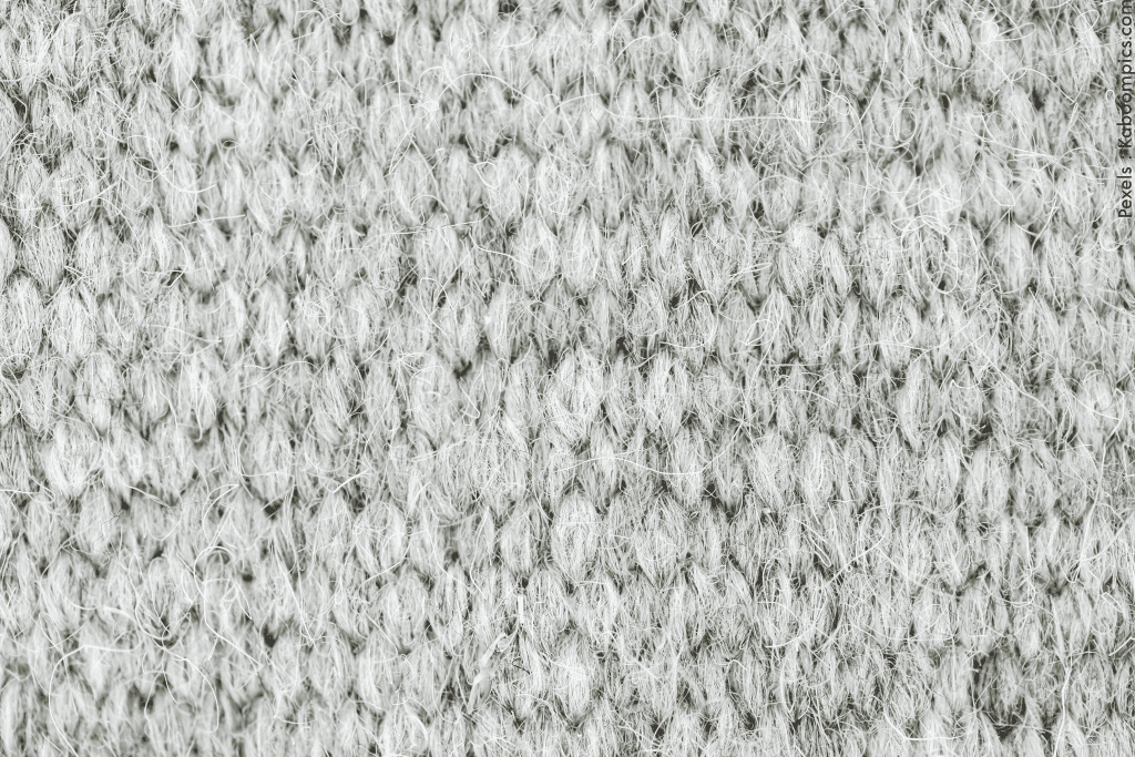 Macro of a grey wool knitted fabric texture showcasing intricate patterns